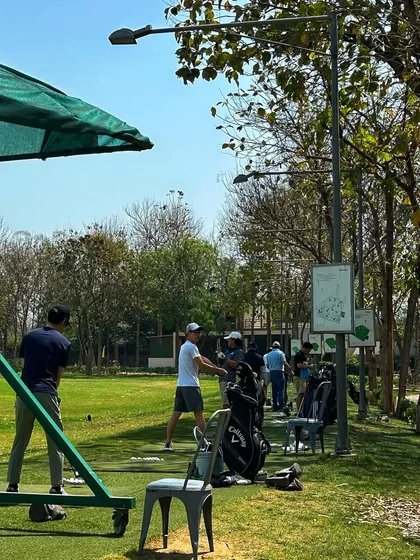 A casual Saturday scene, with golfers practicing and socializing on the range.