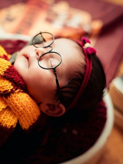 A close-up shot of our little wizard, focusing on the iconic glasses and scarf. Every detail is considered to make these themed portraits feel authentic and magical.
