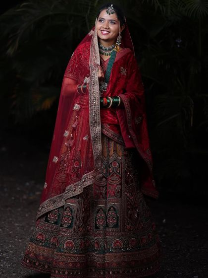 A radiant bride in a magnificent red and gold lehenga. The detailed embroidery and velvet dupatta make this a truly regal choice for a wedding day.