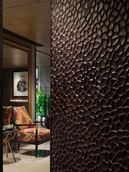 A close-up of a hand-scooped teak wood door from our Caitriona apartment project, showcasing the Japanese 'Shou Sugi Ban' finishing technique. This detail highlights our passion for materials and hands-on craftsmanship, where every texture is chosen with care.