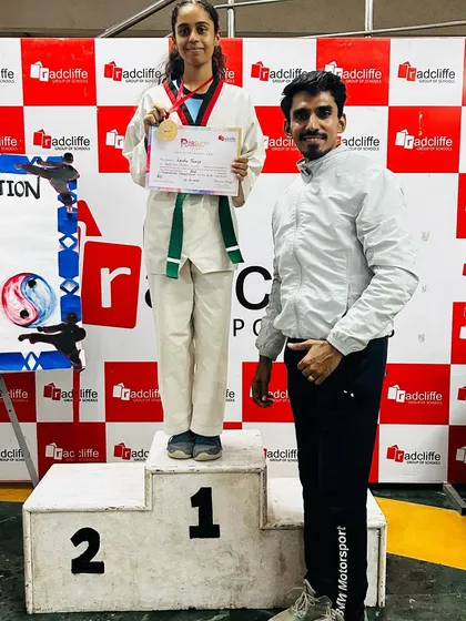 Standing with my gold-medalist student at the Radcliffe School competition.