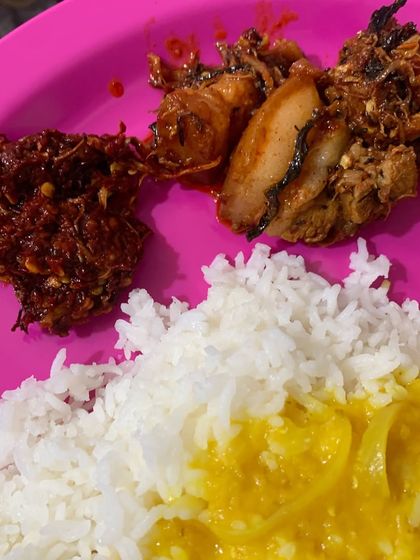 A delicious plate of food featuring pork cooked with dried bamboo shoot, served with dal and my fiery red chilli chutney, which we call Etsu Molu.