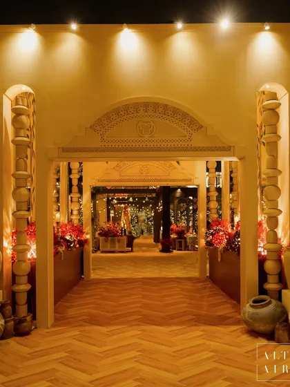 For the 'Mid-Century Mod' sangeet, I designed an entrance that blended modern luxury with earthy, retro elements. The clean lines, herringbone wood flooring, and traditional pottery created a welcoming and stylish first impression.