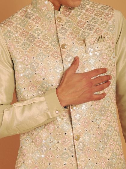A detailed shot of the beige bundi, showing the texture and the subtle shine of the embroidery. It's all about refined elegance.