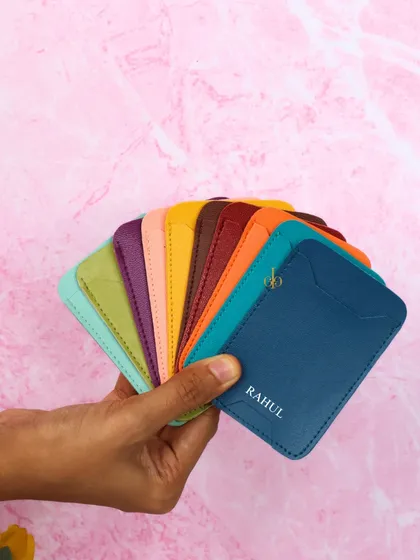 A hand displaying a fan of our colorful phone card holders, showcasing the variety of options available.