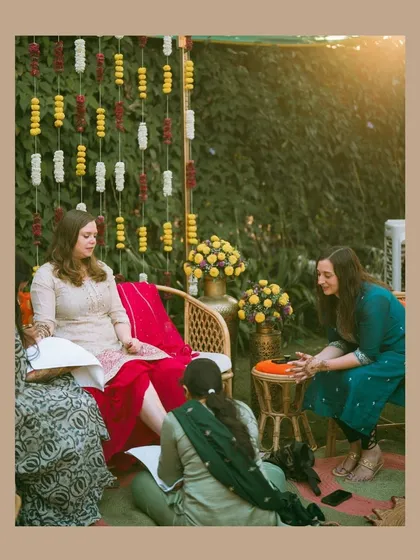 The bride enjoying her Mehendi ceremony, surrounded by friends and family. The rich colors and relaxed atmosphere are beautifully captured in this candid shot.