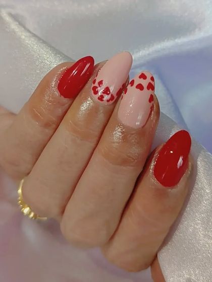 A perfect Valentine's set with bright red nails and a nude accent nail covered in tiny red hearts.