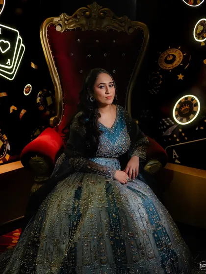 A regal bridal portrait at a casino-themed Sangeet on a cruise. The unique decor and the bride's confident pose make for a truly memorable shot.