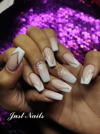 A modern twist on the classic French manicure. This set features a soft pink to white ombre base on coffin-shaped nails, enhanced with delicate silver glitter lines and strategically placed rhinestones at the cuticle for a touch of sparkle.