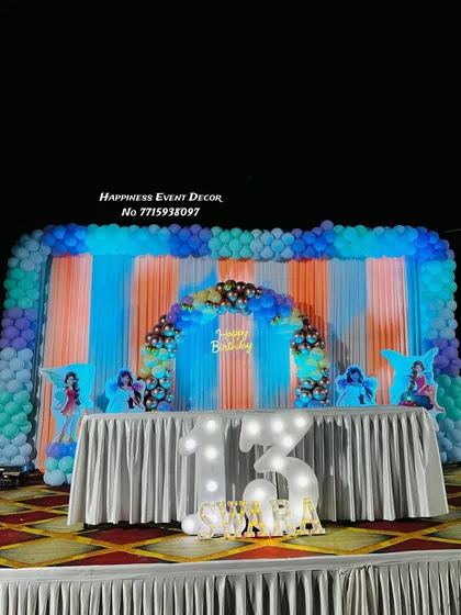 A grand stage decoration for a 13th birthday. This large-scale setup features a full balloon backdrop, a smaller inner arch, and light-up marquee numbers.