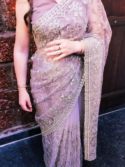 A close-up of the party wear saree. The open pallu allows the intricate embroidery and delicate net fabric to be fully appreciated.