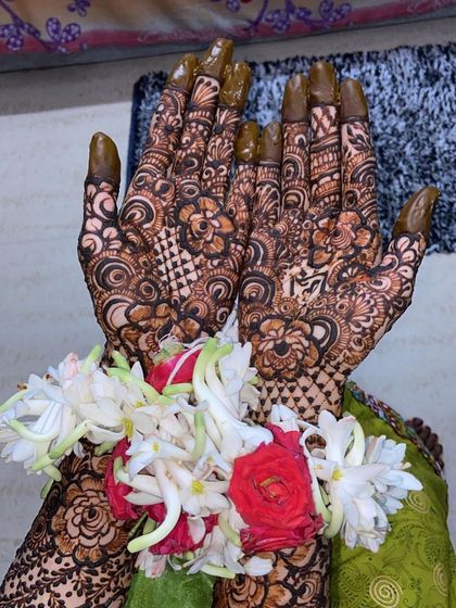 More views of Fathima's bridal henna, showing the personalized name and the stunning floral jewelry that completes the look.