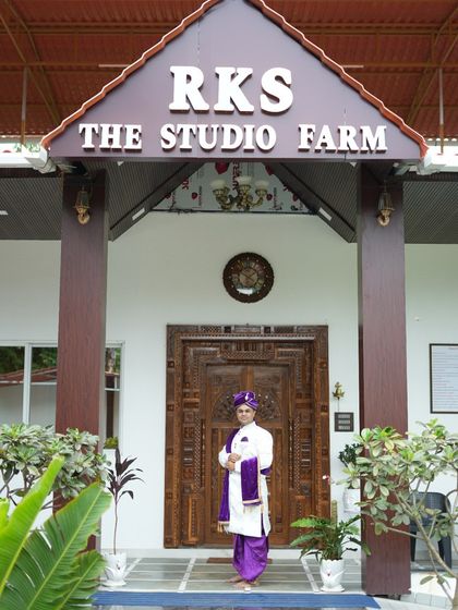 Our client stands proudly in a traditional white sherwani paired with a purple dhoti and pheta. This is a classic groom's outfit, available for rent from our studio.