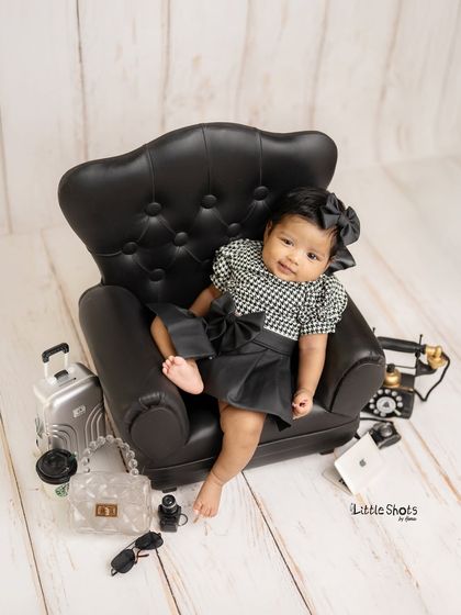 Who's the boss? This little lady, of course! Her stylish outfit, mini armchair, and cool accessories make for a fun and sassy "Boss Lady" themed sitter session.