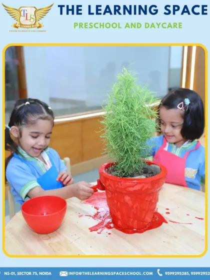 A splash of spring color. Two children work together to paint a pot, learning about teamwork and creativity while engaging in a fun, seasonal art project.