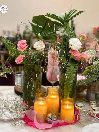 A lush and vibrant centerpiece created for a party. I combined tropical leaves, pink and white carnations, and glowing candles to craft a tablescape that feels both abundant and celebratory.