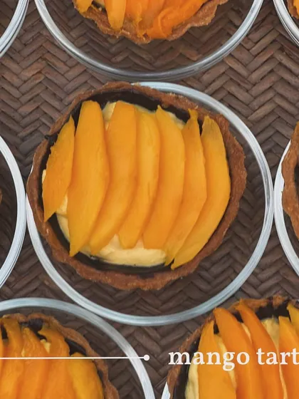 An overhead shot of my individual mango tarts. Slices of fresh mango are beautifully arranged over a creamy custard filling in a crisp tart shell.