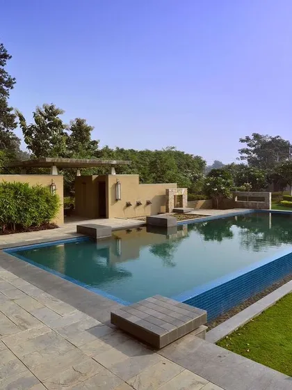 The pool area at C Farm is designed with clean lines and natural materials. Stone decking and integrated planters create a seamless transition from the water to the lawn, while a feature wall adds architectural interest and privacy.