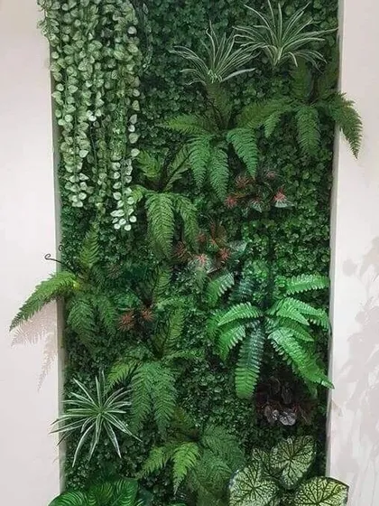 A custom-designed artificial plant panel featuring a variety of textures. We included hanging plants, large ferns, and broad leaves to create a dynamic and artistic green installation.