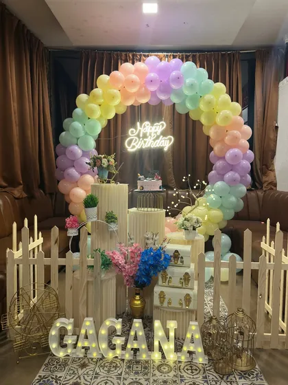 A full ring balloon arch complemented by the birthday girl's name, 'GAGANA', in large marquee letters. This combination creates a fantastic photo opportunity and a personalized focal point for the party.