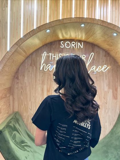 A client showing off the back of her beautifully styled hair in our signature chair.