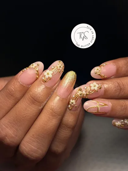 A sophisticated bridal set featuring 3D white flowers, delicate gold beadwork, and a sparkling gold glitter accent nail.