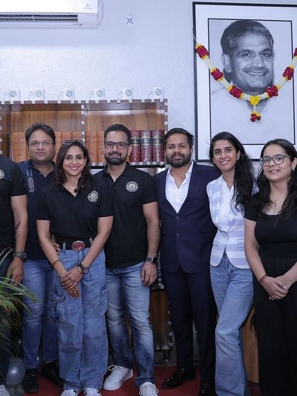 Standing before my father's portrait at the library inauguration. His dream and legacy are the driving force behind my passion for this profession.