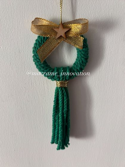 A simple and elegant green wreath ornament with a tassel and a wooden star. This design has a lovely rustic charm.