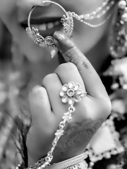 An artistic close-up in black and white, highlighting the bride's smile and her traditional nose ring.