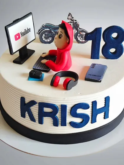 A customized cake for an 18-year-old who loves YouTube, gaming, and bikes. All his favorite things are represented in fondant on this special birthday cake.