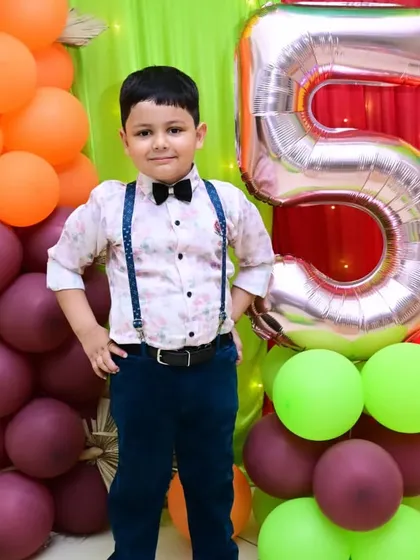 A dapper birthday boy posing for a photo at his 5th birthday party. We help capture these stylish moments.