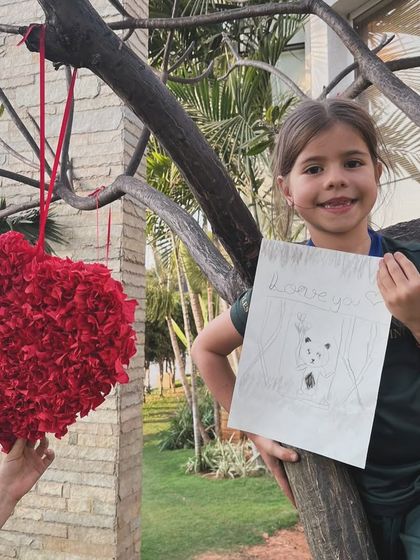 This young artist shows off her sweet panda drawing, complete with a bamboo background, while enjoying the fresh air.