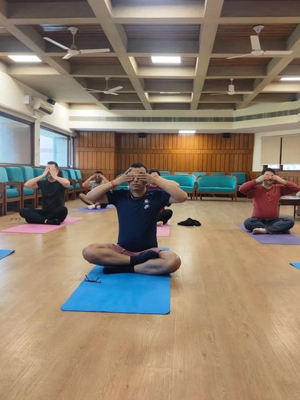 Students practicing Bhramari pranayama, the humming bee breath, during an international teacher training course. This practice is excellent for calming the mind, relieving stress, and improving concentration by creating soothing internal vibrations.