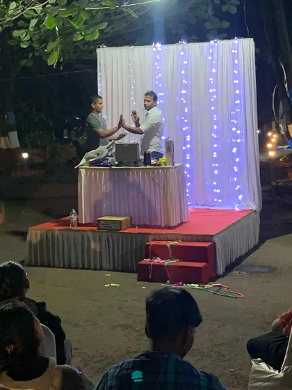 Here I am on stage with a volunteer during an outdoor evening show in Alibag. My performances are flexible and can be set up anywhere, from a garden to a grand stage, to fit your event perfectly.