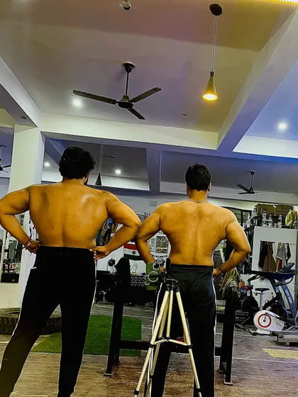 Results speak for themselves. Here I am with a client, both of us showing the back definition that comes from a combination of heavy lifting and a clean, high-protein diet.