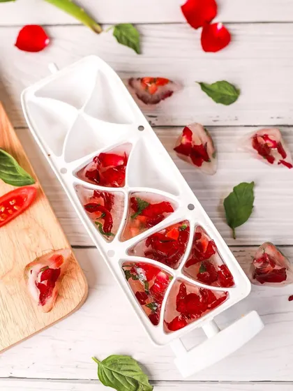 A beautiful shot of DIY ice cubes made with rose petals and basil. The bright, clean styling is perfect for beauty and wellness content.