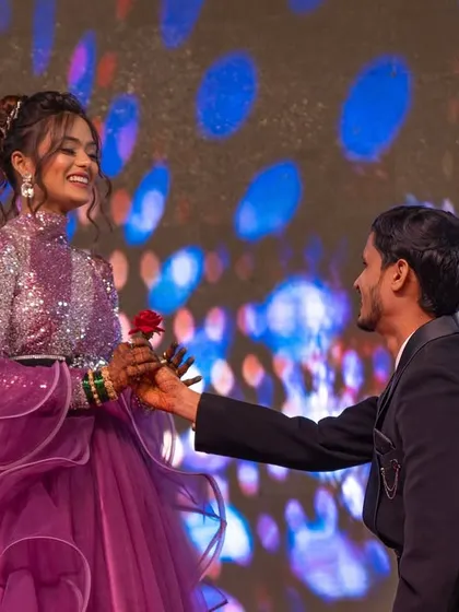 A romantic moment from the Sangeet, where the groom gets on one knee to offer the bride a rose on stage.