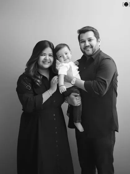 A picture-perfect family of three, smiling warmly for the camera. These simple, elegant portraits are a treasure.