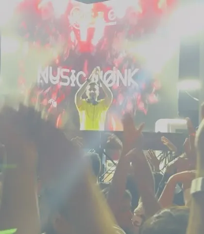 A slightly blurred, high-energy shot of me with my hands up, mirroring the crowd. This image captures the motion and raw energy of the party.