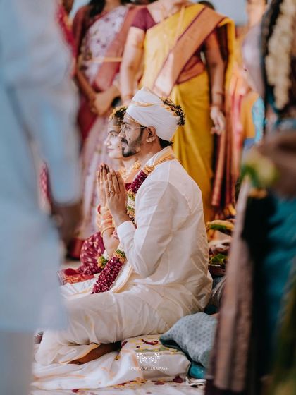 The couple seated in prayer, a side view capturing the solemnity and beauty of the wedding ceremony.