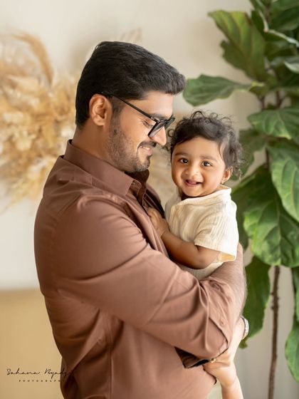 A father and son share a happy moment, their smiles lighting up the frame.