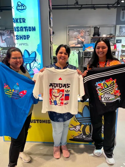 A group of friends and family proudly displaying their new custom-printed t-shirts. Our live apparel printing is a great activity for group outings.