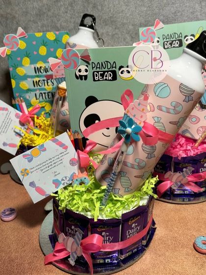 Another angle of our creative candy-themed return favours. The chocolate base holds a personalised sipper, a cute diary, colour pencils, and other fun stationery items for a 6th birthday party.