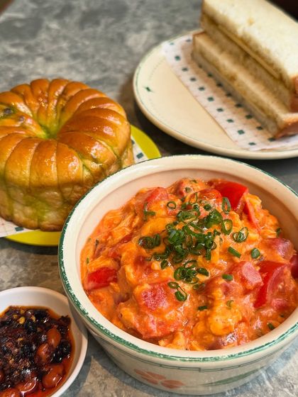 A simple and satisfying meal of creamy scrambled eggs with fresh tomatoes, served alongside a fluffy pandan bun and our house made chili oil. It’s a comforting option for any time of day, paired perfectly with a hot Kopi or Teh Tarik.