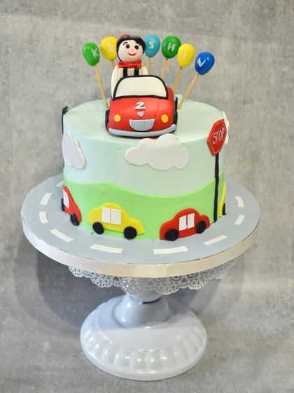 Another angle of the car-themed birthday cake, highlighting the fondant cars and traffic light details.