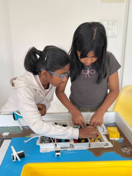 Collaboration is crucial for success. Two students work together on their robot for the Indian Robotics Olympiad, combining their building and programming skills to solve the challenge.