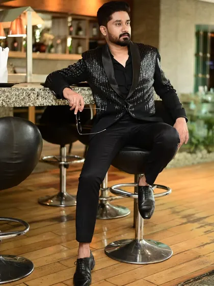 A client looking relaxed and stylish in our black sequin blazer. It's the perfect outfit for a night out or a celebratory dinner.