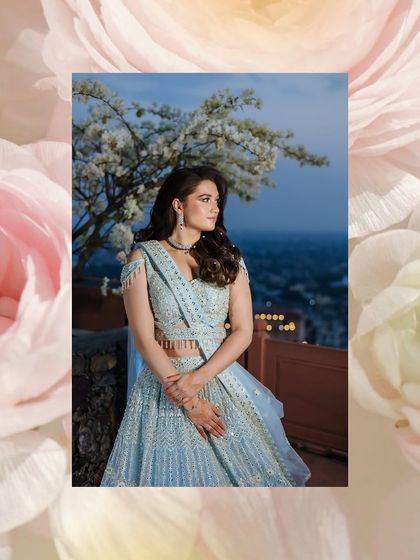 An artistic portrait of a bride against a twilight sky, framed by a pink floral border.