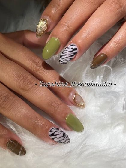 An earthy, mixed-pattern set. I combined solid olive and brown nails with a hand-painted zebra print and a cat eye accent with a gold chrome border.