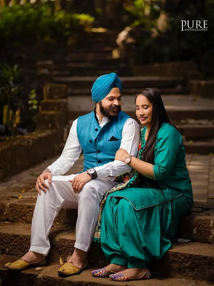 Karan and Simarpreet sit together on stone steps in a park, sharing a quiet conversation. This candid style of photography captures the real, everyday connection between a couple.